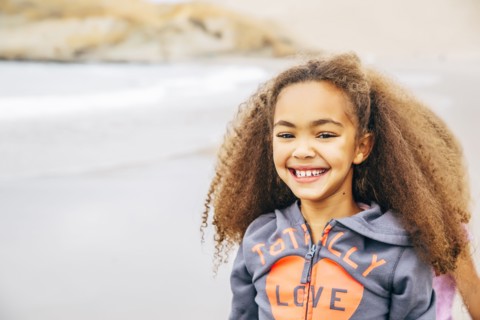 Mixed race girl smiling on beach