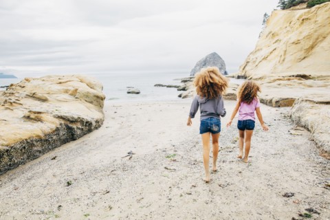 Mixed race sisters walking on beach