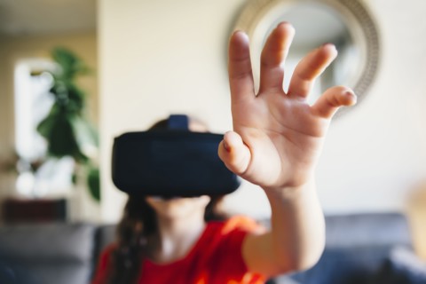 Mixed race girl using virtual reality goggles