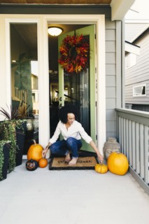 Mixed race woman arranging pumpkins on patio