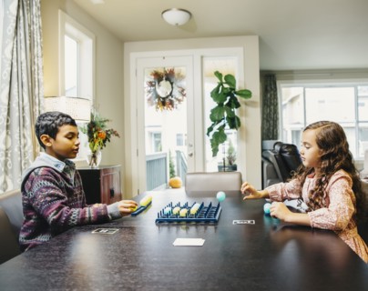 Mixed race siblings playing board game