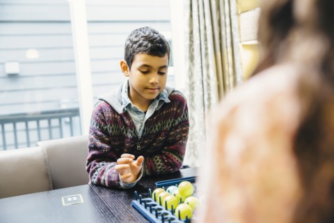 Mixed race siblings playing board game
