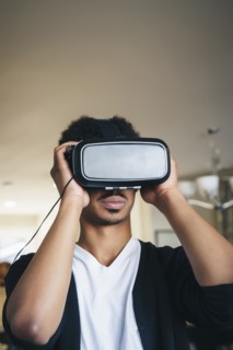 Mixed race man using virtual reality goggles