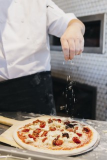 Chef making pizza in restaurant in kitchen