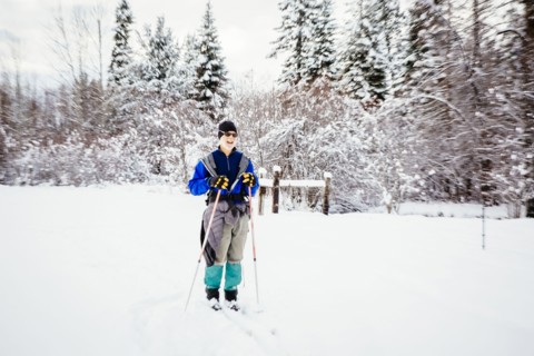 Caucasian woman cross-country skiing in snowy field