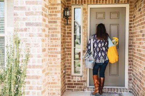 Hispanic woman opening front door
