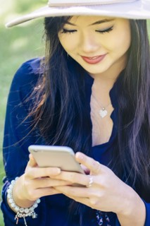 Chinese woman using cell phone outdoors