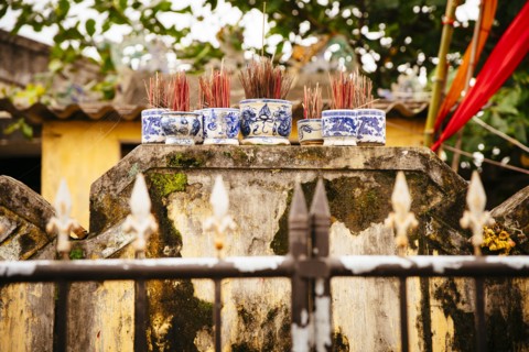Close up of incense sticks behind fence