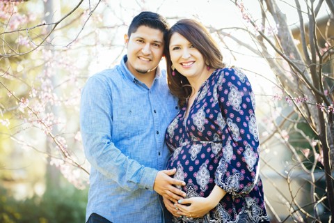 Pregnant Hispanic couple smiling outdoors