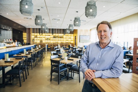 Smiling Caucasian man leaning on counter at restaurant