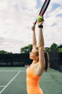 Caucasian woman stretching arms on tennis court