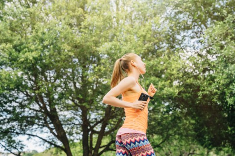 Caucasian woman listening to earbuds while running