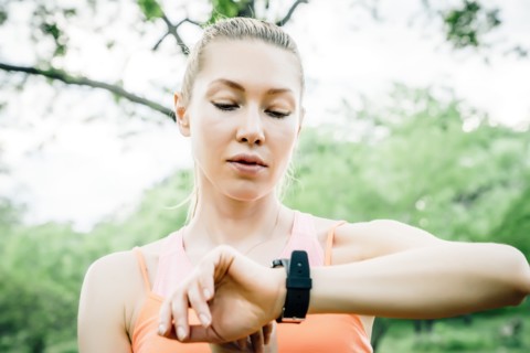 Caucasian woman checking the time on wristwatch outdoors