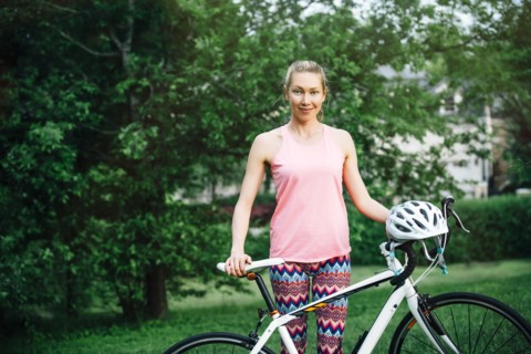 Smiling Caucasian woman posing holding bicycle