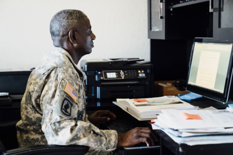 Black soldier using computer