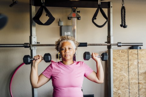 Black woman lifting weights in garage