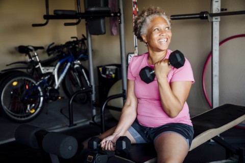 Black woman lifting weights in garage