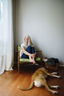 Caucasian woman sitting in armchair near dog