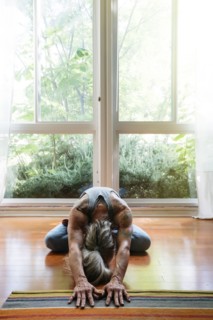 Caucasian woman stretching on floor