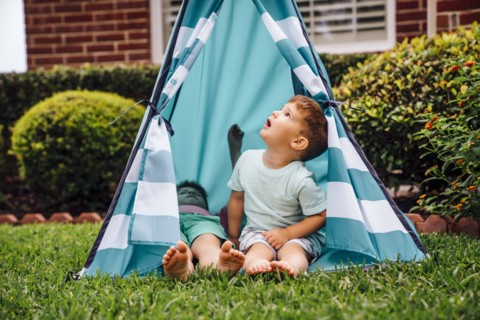 Caucasian brothers in backyard teepee