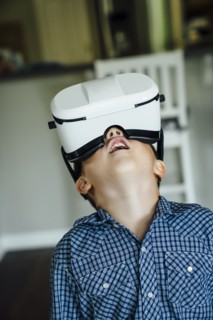 Caucasian boy wearing virtual reality goggles