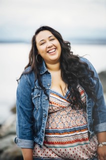 Smiling Mixed Race woman near ocean