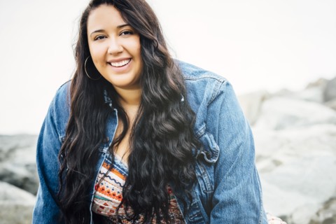 Smiling Mixed Race woman near ocean