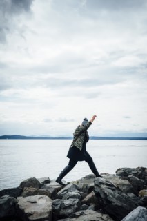 Mixed Race woman walking on rocks near ocean