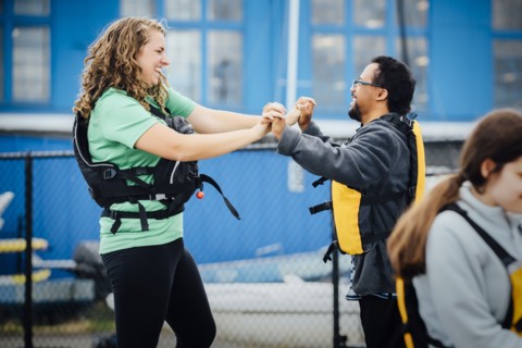 Man and woman wearing life-jackets holding hands