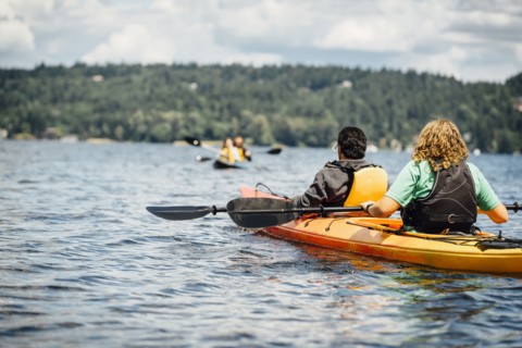 Man and woman holding paddles in kayak