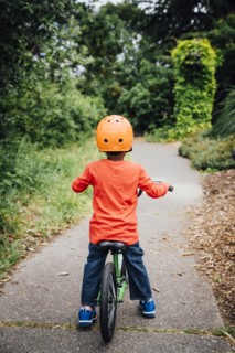 Black boy on bicycle wearing helmet