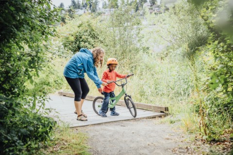 Mother helping son ride bicycle