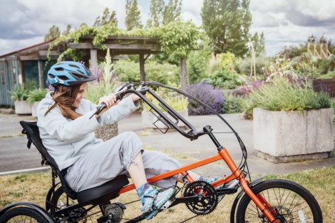 Caucasian woman riding tricycle