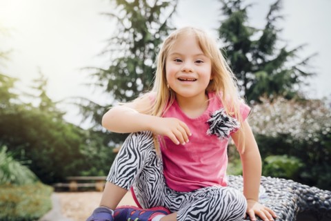 Smiling Mixed Race girl sitting on bench