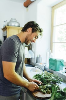 Caucasian man chopping vegetables in kitchen