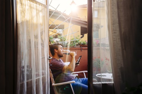 Caucasian man reading digital tablet drinking red wine