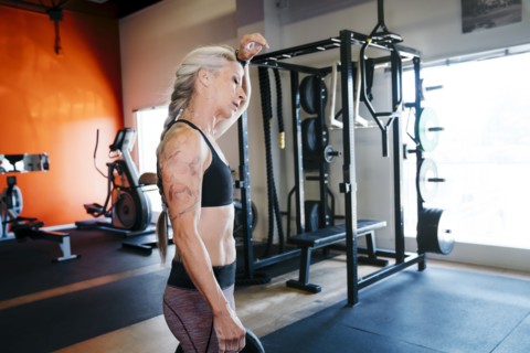 Caucasian woman sweating in gymnasium