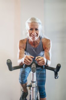 Caucasian woman riding stationary bicycle
