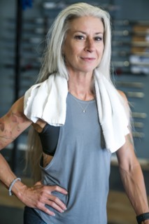 Caucasian woman posing in gymnasium wearing towel