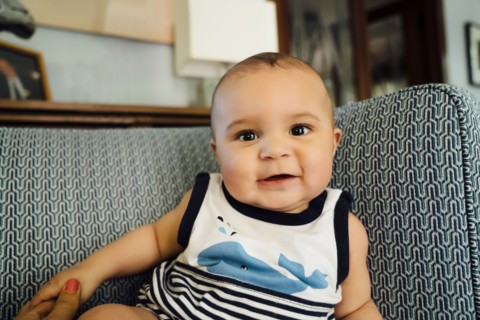 Portrait of smiling Mixed Race baby boy on chair