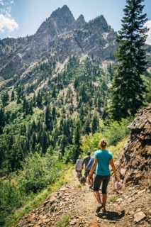 Caucasian people hiking on path in mountains