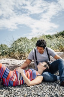 Pregnant lesbian couple relaxing on rocky beach