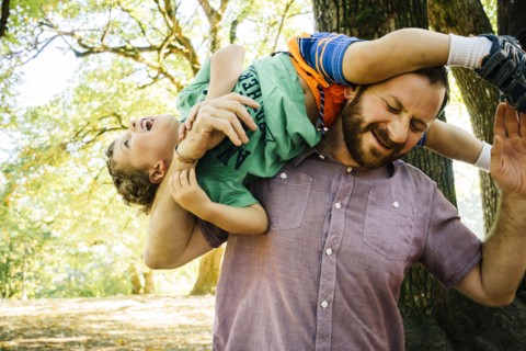 Caucasian father playing with son on shoulder