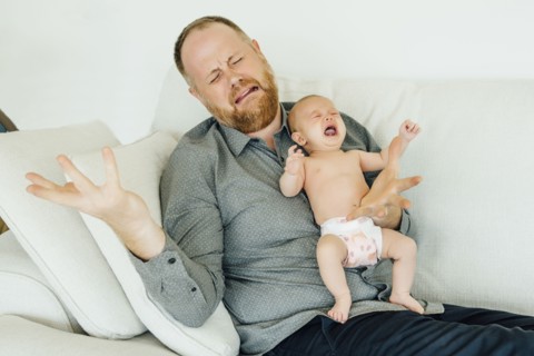 Portrait of crying father holding crying baby daughter