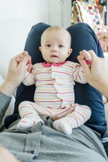 Father playing with baby daughter in lap