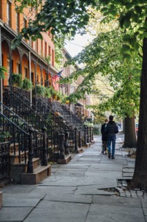 Couple pushing stroller on city sidewalk