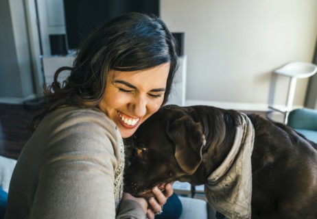Mixed Race woman hugging dog
