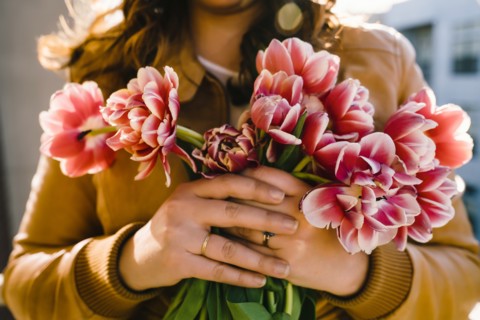 Hands of Mixed Race woman holding flowers