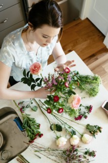 Woman arranging flowers at table