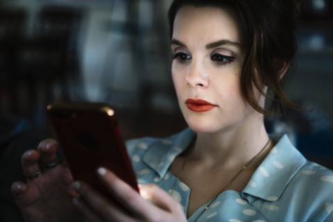 Woman texting on cell phone in the dark